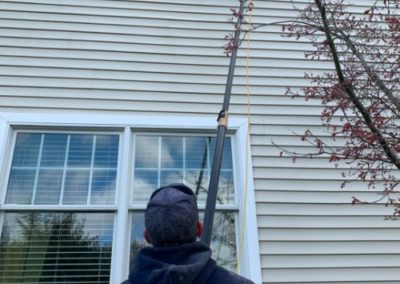 employee cleaning a high window from the ground in Monmouth County, NJ