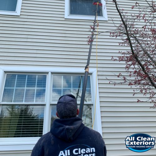 employee cleaning a high window from the ground in Monmouth County, NJ
