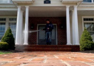 employee pressure washing a front porch in Monmouth County, NJ