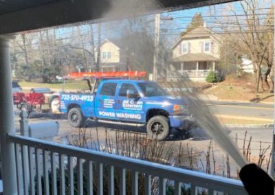 close up power washing the roof of a porch in Monmouth County, NJ